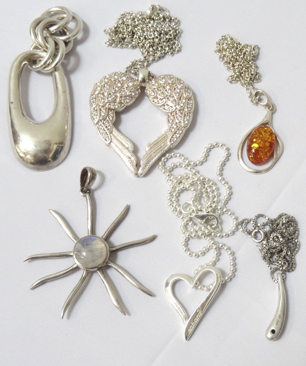 SIX SILVER PENDANTS four with silver chains, including one in the form of angel wings,