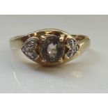 SMOKY TOPAZ AND DIAMOND DRESS RING the central oval cut topaz flanked by a small diamond to each