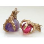 TWO NINE CARAT GOLD CLAW PENDANTS one claw holding a purple agate bead and the other a circular