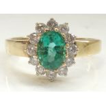 EMERALD AND DIAMOND CLUSTER RING the central oval cut emerald approximately 0.