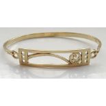 NINE CARAT GOLD BANGLE with Mackintosh style decoration to the hinged top plaque, approximately 9.