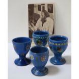 FOUR ANTON LANG POTTERY EGG CUPS two decorated with flowers and two with stylized motifs,