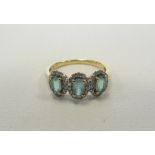 AQUAMARINE AND DIAMOND TRIPLE CLUSTER RING each of the three oval cut aquamarines in diamond