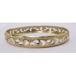 FOURTEEN CARAT GOLD BANGLE with pierced scroll decoration, approximately 13.3.