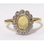 OPAL AND DIAMOND CLUSTER RING the central oval cabochon opal in twelve diamond surround,