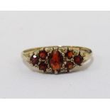 ORANGE GEM SET CLUSTER RING on nine carat gold shank,