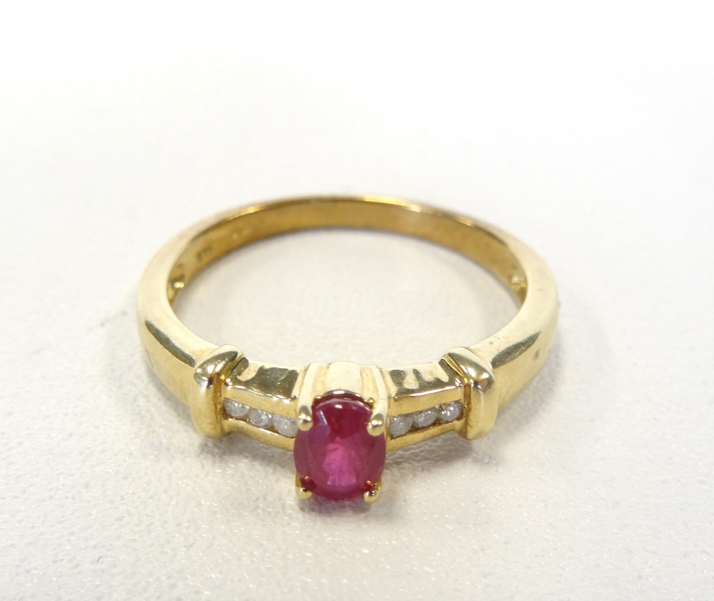 RUBY AND DIAMOND RING the central oval cut ruby flanked by three channel set diamonds to each