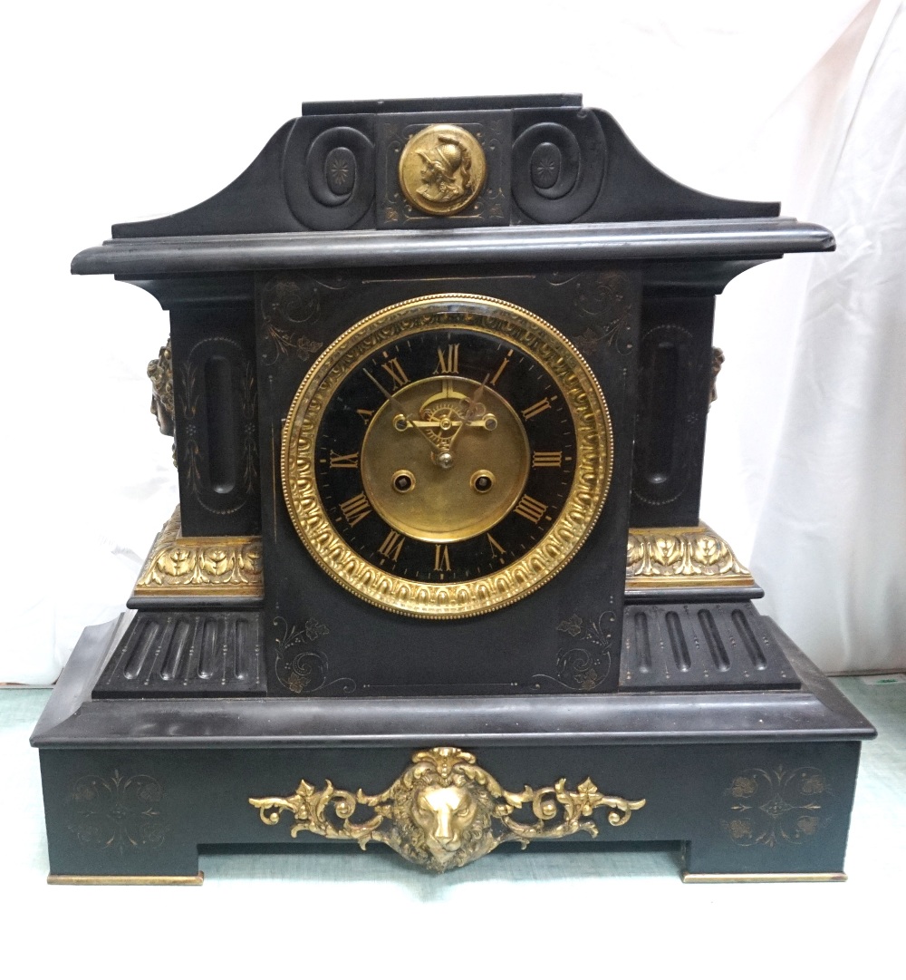 VICTORIAN BLACK SLATE MANTLE CLOCK with a shaped top applied with a gilt metal plaque above a