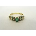 EMERALD AND DIAMOND DRESS RING the central oval cut emerald flanked by alternating rows of diamonds