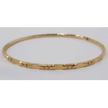 UNMARKED HIGH CARAT GOLD BANGLE with cut decoration, approximately 10.