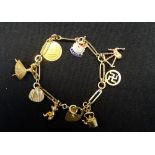 NINE CARAT GOLD CHARM BRACELET with heart attachment and various charms including a ballerina and