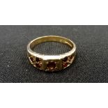 GARNET CLUSTER RING the central garnet flanked by three smaller garnets to each shoulder,