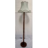 OAK STANDARD LAMP with a turned column raised on a circular base, with a shaped mint green shade,