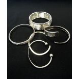 FIVE SILVER BANGLES of various sizes and designs,