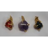 THREE NINE CARAT GOLD CLAW PENDANTS one claw holding a purple agate bead,