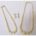 IVORY BEAD NECKLACE of graduated form and comprising fifty five graduated beads with a later silver