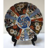 JAPANESE IMARI CHARGER with a scalloped rim and panels decorated in terracotta,