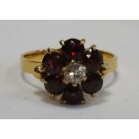 GARNET AND DIAMOND CLUSTER DRESS RING the six garnets surrounding the central diamond,