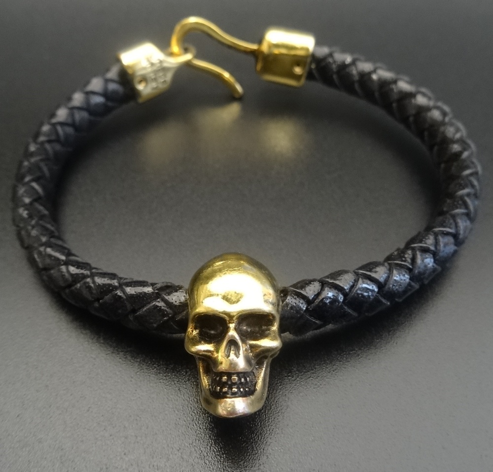 ALEXANDER McQUEEN SKULL LEATHER BRACELET the brass skull on a plaited leather bracelet,