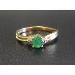 EMERALD AND DIAMOND RING the central oval cut emerald flanked by three small diamonds to each