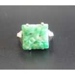 ART DECO CARVED JADE RING the square jade panel flanked by stepped shoulders,