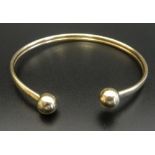 NINE CARAT GOLD BANGLE with ball finials, approximately 4.