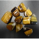 TEN POLISHED TIGER'S EYE PENDANTS of varying sizes and shapes (10)