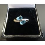 BLUE TOPAZ AND DIAMOND RING on nine carat gold shank with twist setting,