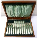 SET OF EDWARDIAN MOTHER OF PEARL HANDLED FRUIT KNIVES AND FORKS in fitted oak case,