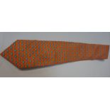 HERMÈS SILK TIE in orange and decorated overall with small blue fish