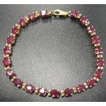 RUBY AND DIAMOND LINE BRACELET each the twenty-two oval cut rubies separated by two small diamonds,