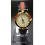 LADIES GUCCI WRISTWATCH the circular champagne dial within red and black enamel set bezel,