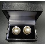 LARGE PAIR OF PEARL AND CZ STUD EARRINGS the central pearl on each within two row CZ surround,