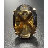 SMOKY TOPAZ SINGLE STONE DRESS RING the oval cut topaz on nine carat gold shank with raised setting