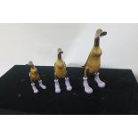 A SUITE OF THREE CARVED WOODEN GEESE,