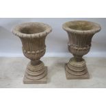 A PAIR OF COMPOSITION STONE URNS, each of circular tapering form moulded in relief with foliage,