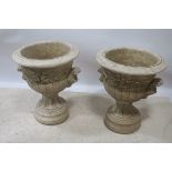 A PAIR OF COMPOSITION STONE URNS,