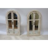 A PAIR OF CONTINENTAL WHITE PAINTED WALL MIRRORS, modelled as doors,