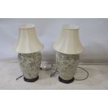 A PAIR OF TABLE LAMPS, each of ovide tapering form, the white ground decorated with flowerheads,