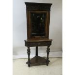 AN OAK CARVED CORNER CABINET,