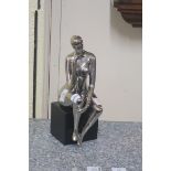 A CHROMED MODEL OF A SEATED FEMALE NUDE,