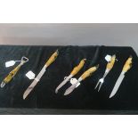 A COLLECTION OF FLATWARE, with rabbit paw handles and chrome blades, including a bottle opener,