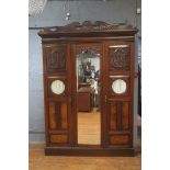 A MAHOGANY CARVED ARTS AND CRAFTS STYLE THREE DOOR WARDROBE,