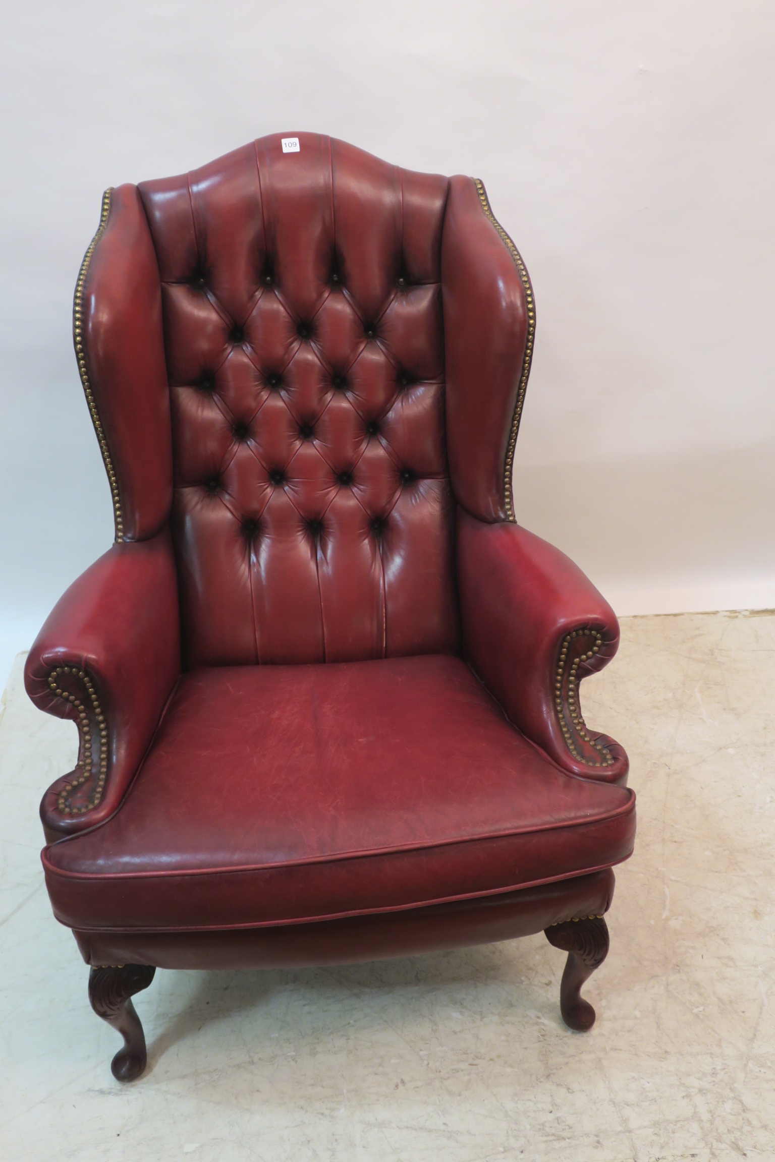 A GEORGIAN DESIGN HIDE UPHOLSTERED WING CHAIR,