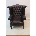 A HIDE UPHOLSTERED WING CHAIR,