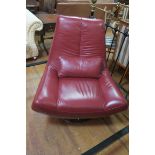 A WINE HIDE UPHOLSTERED DESIGNER SWIVEL CHAIR, raised on a circular white metal base,