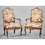 Pair of Italian Rococo Carved Walnut Armchairs, 18th c., serpentine crest rail, padded back and arms
