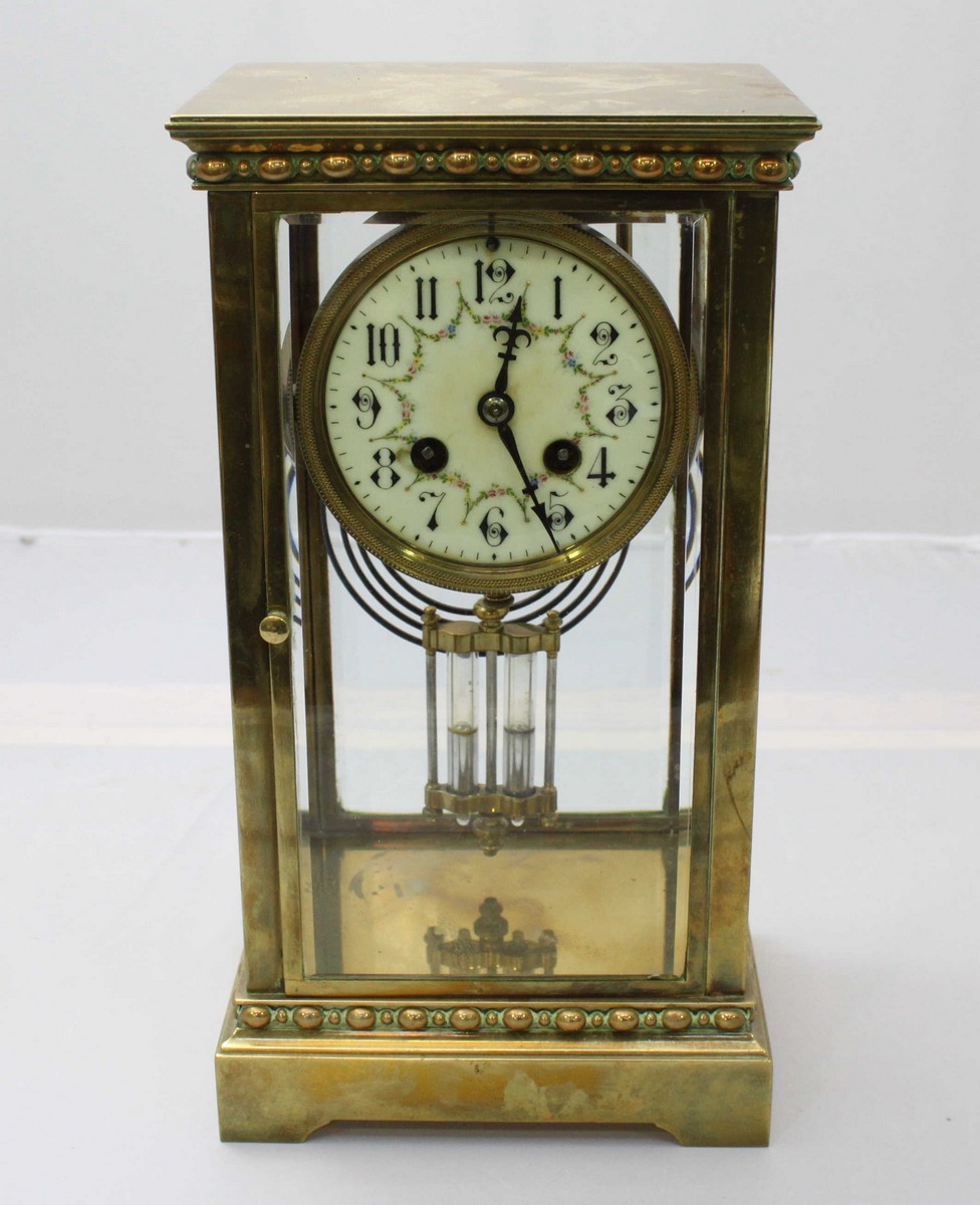 An Edwardian brass mantel clock, the white dial with Arabic numerals denoting hours, eight day