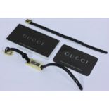 A lady's gold plated Gucci wristwatch with black face and black leather strap, (spare strap