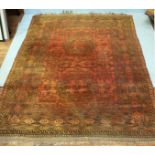 A Caucasian hand-knotted carpet with two central guls to a brick red ground and geometric multi-